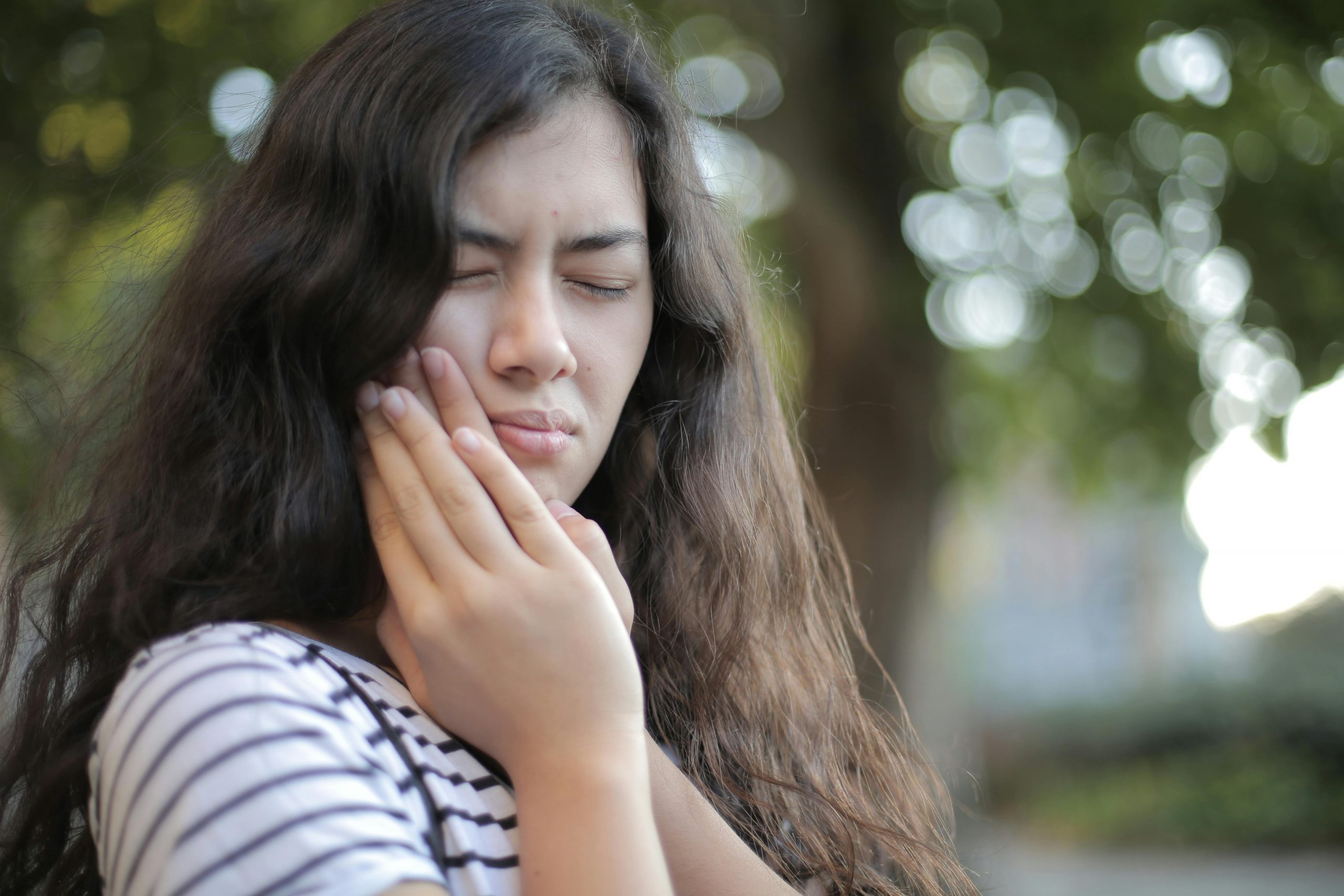 woman in pain holding her jaw with both hands
