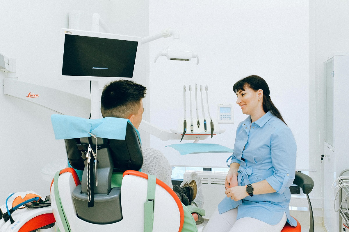 dentist talking with her patient sitting in a dental chair