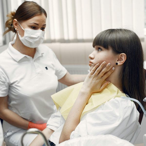 dentist with her patient holding her jaw