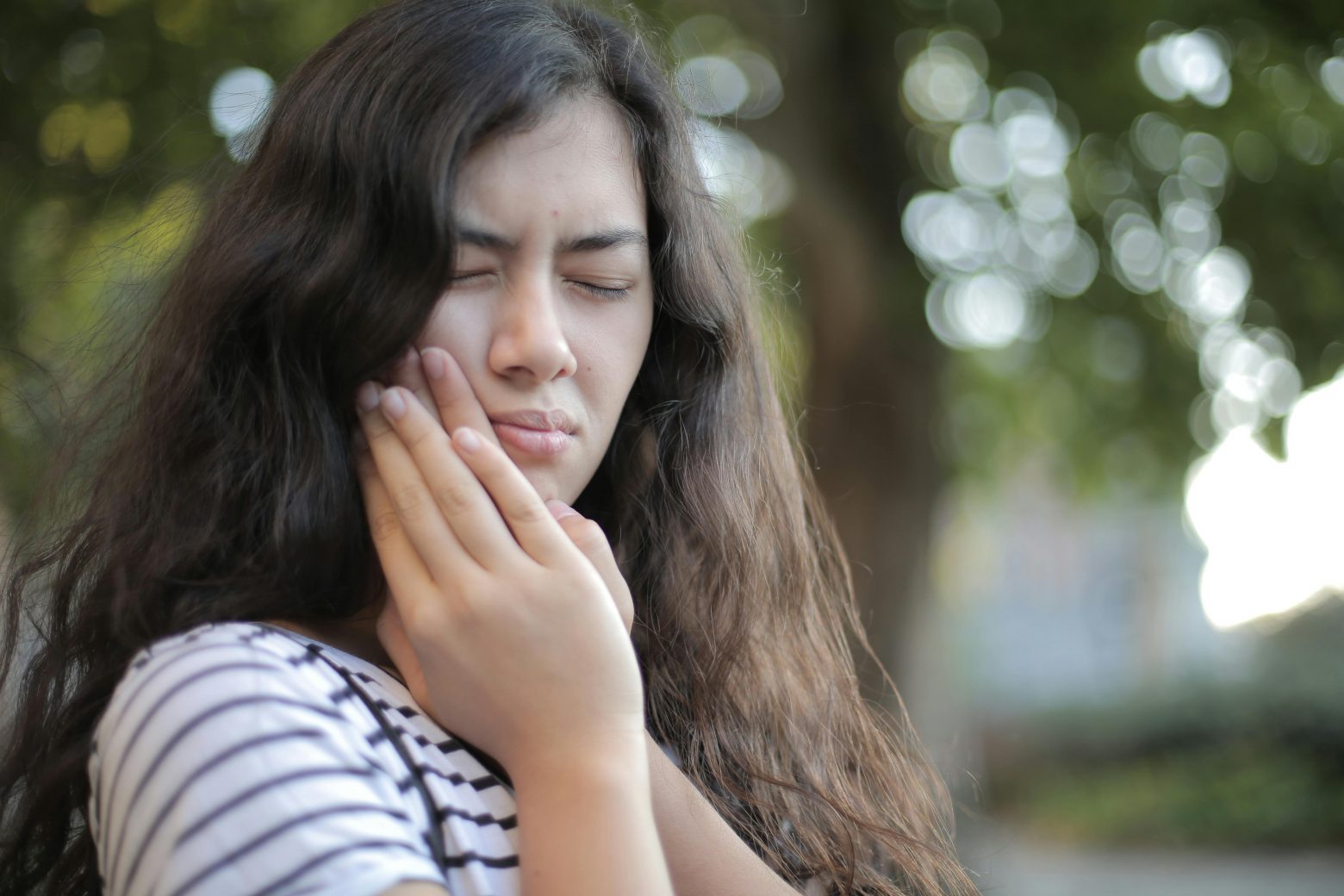 woman in pain holding her jaw with both hands